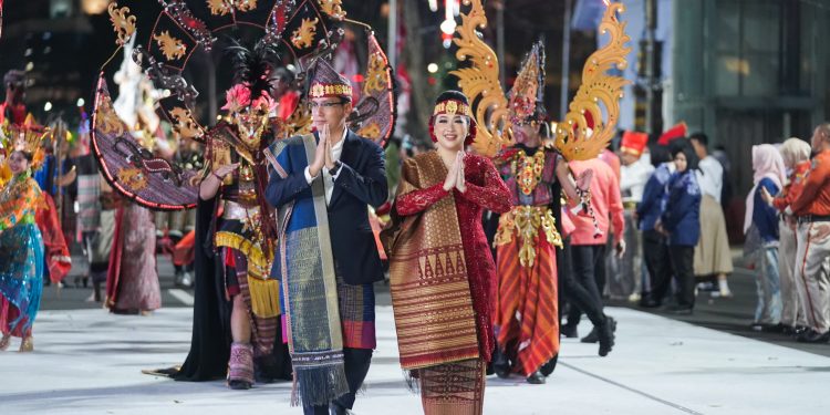 Kenakan Pakaian Adat Toba, Wali Kota Rico & Ketua TP PKK Ikuti Karnaval Budaya Munas APEKSI